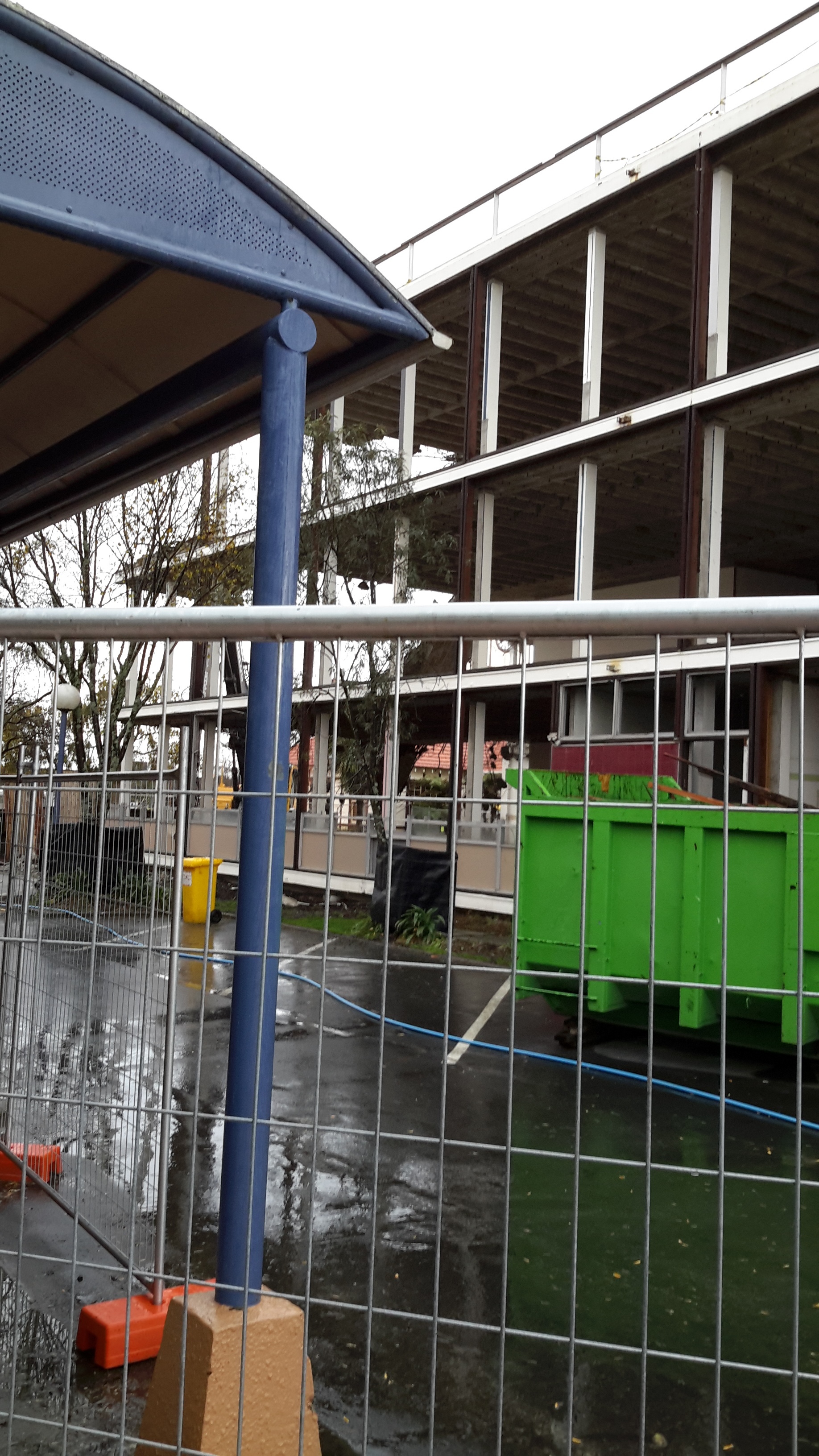 Photograph showing the start of the demolition of Community House with windows frames removed
