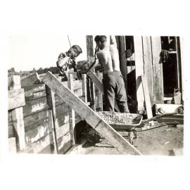 Photograph of Richard Robinson and helper starting work on the new cowshed, ca.1958