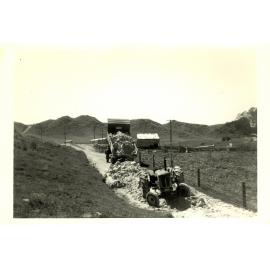 Photograph of Tui Ridge Farm with tractor and truck of rocks, ca.1959