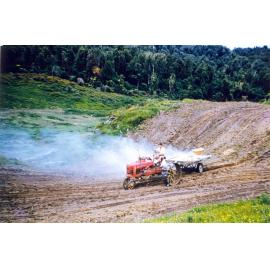 Photograph of Mr Robinson sowing grass for the airstrip, ca.1959