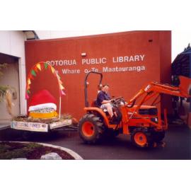 Photograph of library staff driving the tractor, with fletcher's egg on the trailor