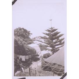Black and white photograph of a camping scene at the beach