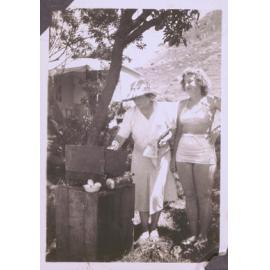 Black and white photograph of two women tending a barbecue