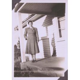 Black and white photograph of a woman on a porch