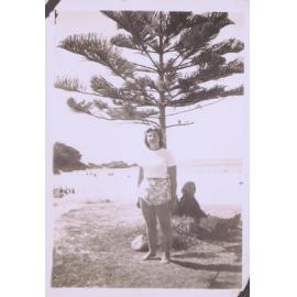 Black and white photograph of unidentified individual with beach scene as backdrop