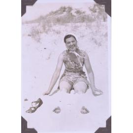 Black and white photograph of a young woman at the beach