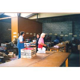 Photograph of Volunteers sorting donations for the Book Fair at a garage in White Street