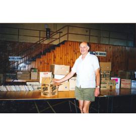 Photograph of Hanno Fairburn sorting books in the Sportsdrome