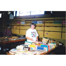 Photograph of Sue Haddock stacking the table with books