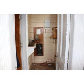 Photograph of the old Whakarewarewa Post Office, showing a side room with telephones
