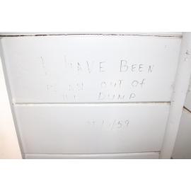 Photograph of the inside of the Rotorua Gaol House 1905-1965, showing an example of a prisoner's message