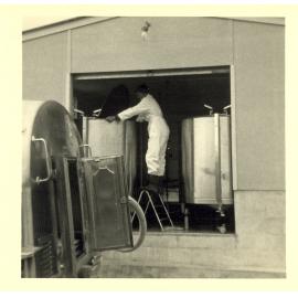 Photograph of Mr Cam Neil stirring the first milk to be collected from the Reporoa factory, 1968