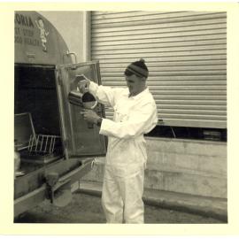 Photograph of Mr Cam Neil sampling milk in a tanker, 1968