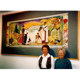 Photograph of an embroidered wall-hanging at Rotorua Library, showing the designer and a member of the Rotorua Embroiderer's Guild