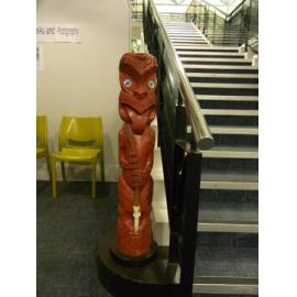Photograph of a tekoteko installed at the base of Rotorua Library's mezzanine stairs