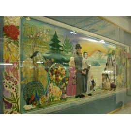 Photograph of an embroidered wall-hanging after the installation of a perspex frame for preservation