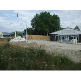 Photograph showing the chapel end of Grey's Funeral Home, with piles of rubble and dirt